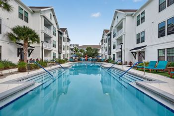 Custom pool area with fire pit lounge, grills, hot tub, and community tables